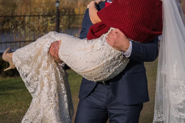 Ženich má nevěsta v náručí na pozadí kouře — Stock fotografie