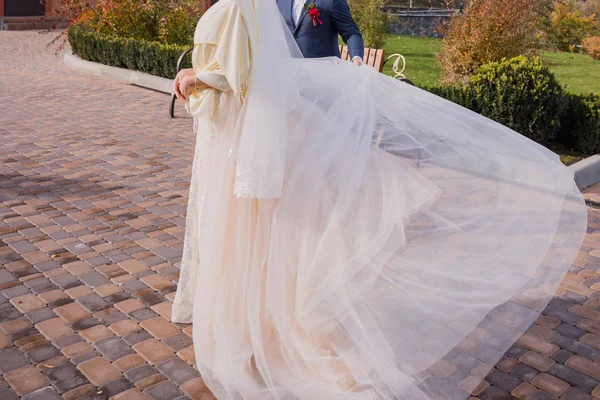 Bride waves a dress in the wind in the park — Stock Photo, Image