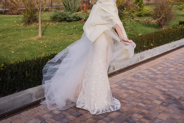 新娘在公园里的风中挥舞着一件衣服 — 图库照片