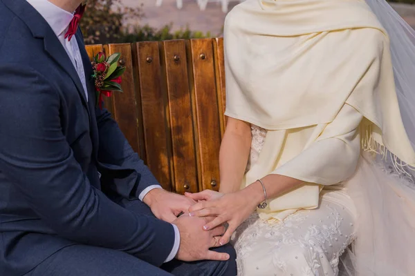 Невеста сидит на скамейке с женихом — стоковое фото
