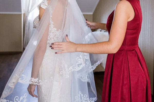 Подруга надела свадебное платье на невесту — стоковое фото