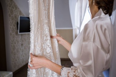 Gelin gelinlik elinde tutan bornoz