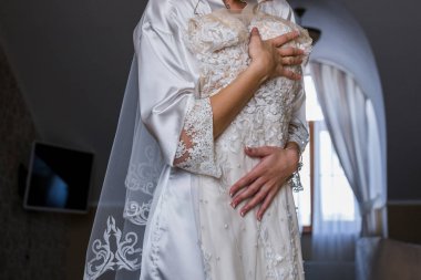 Gelin gelinlik elinde tutan bornoz