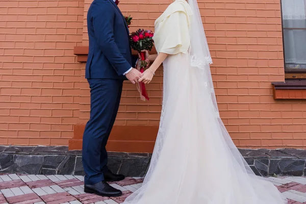 Sposa e sposo stare insieme contro il muro di mattoni — Foto Stock