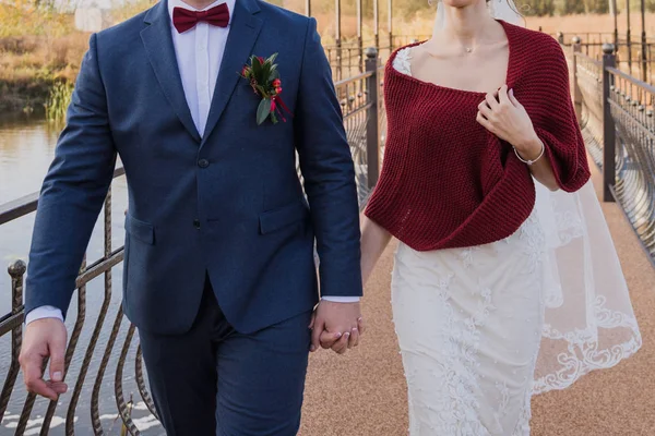 Жених и невеста осенью ходят по мосту — стоковое фото