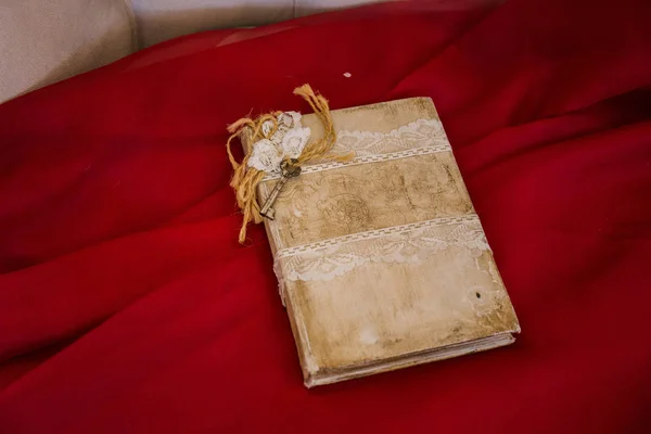 Винтажная книга лежит на красной ткани — стоковое фото