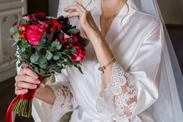 Mariée en peignoir tenant son bouquet de mariage — Photo