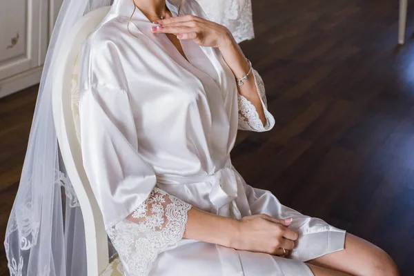 Невеста в халате сидит на стуле — стоковое фото