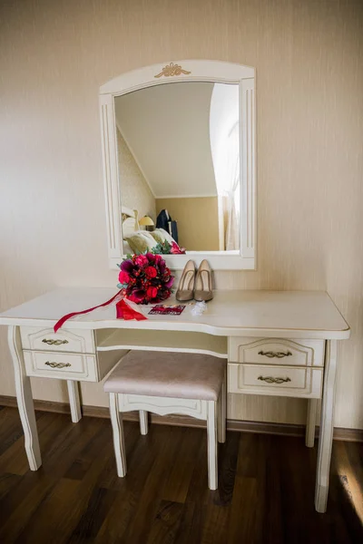 Scarpe e bouquet da sposa alla sposa sul tavolo con specchio — Foto Stock