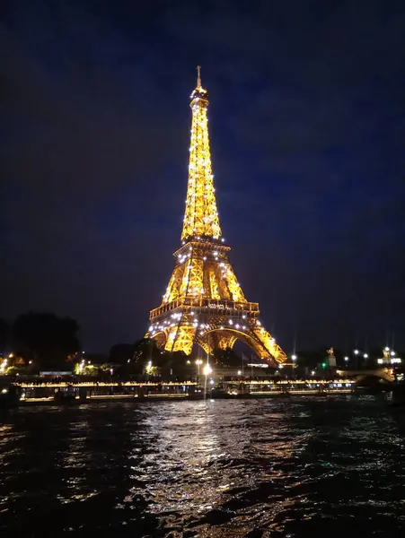 A Torre Eiffel ilumina-se à noite lindamente — Fotografia de Stock