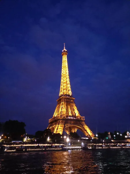 A Torre Eiffel ilumina-se à noite lindamente — Fotografia de Stock