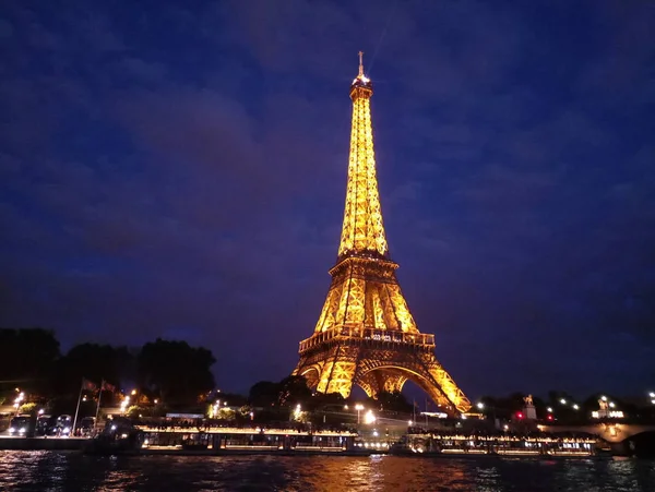 A Torre Eiffel ilumina-se à noite lindamente — Fotografia de Stock