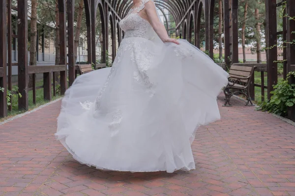 Noiva no vestido de noiva gira no parque — Fotografia de Stock