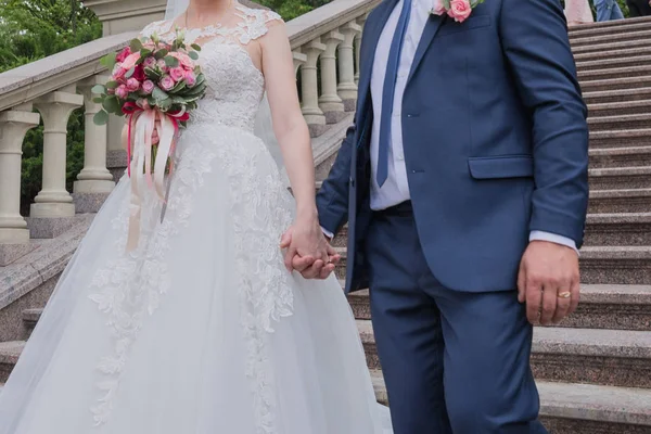Menyasszony és a vőlegény együtt járunk a kezét a parkban — Stock Fotó