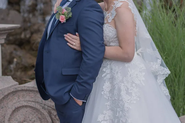 Bruden och brudgummen kramas i parken — Stockfoto