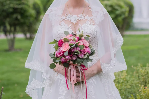 Noiva segura seu buquê de casamento em suas mãos — Fotografia de Stock