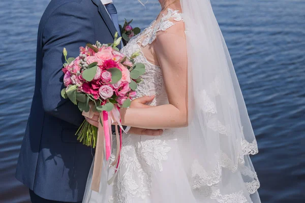 Sposa e sposo stare insieme contro l'acqua — Foto Stock