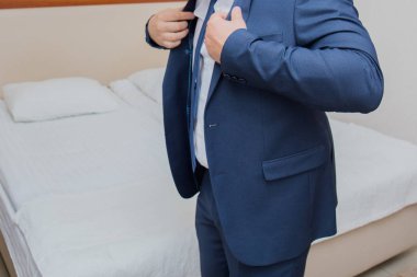 odadaki adam bir takım elbise ceket koyar