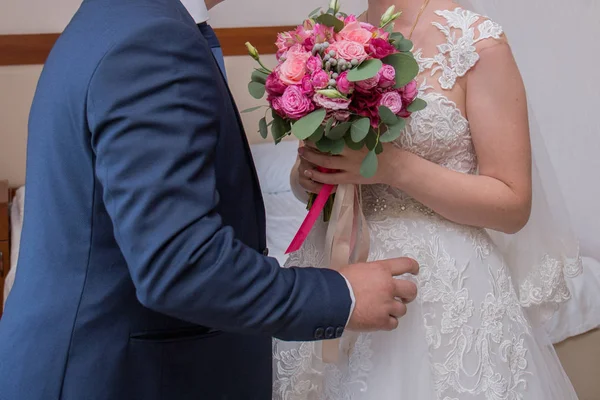 Наречений у костюмі тримає весільний букет — стокове фото