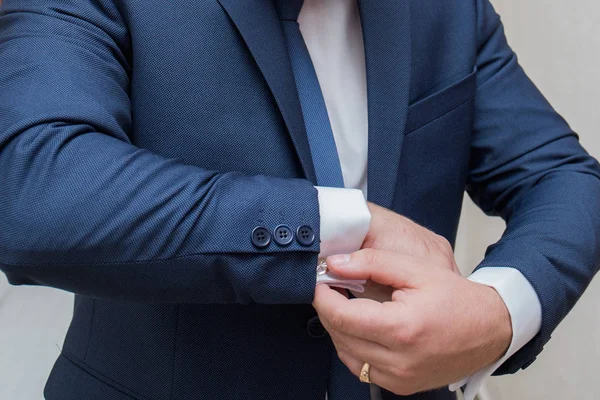 The groom fastens the cuffs of the sleeves on the shirt — Stock Photo, Image