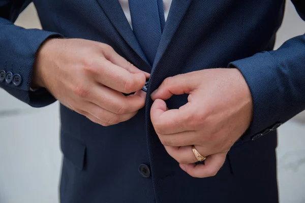 The man in the room puts on a suit jacket — Stock Photo, Image