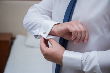 adam otel odasında bir kravat giyiyor