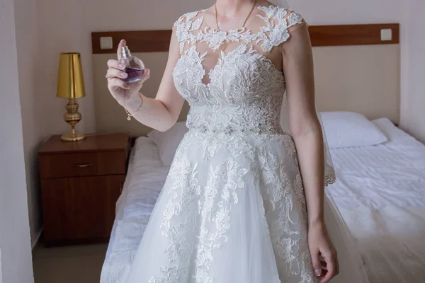 Невеста в свадебном платье распыляет духи — стоковое фото