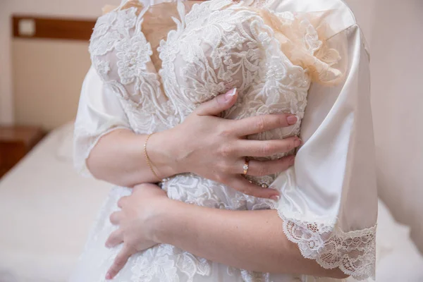 Noiva em vestido de vestir segurando vestido de noiva — Fotografia de Stock