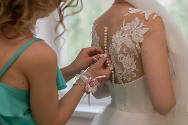 Noiva colocar um vestido de noiva no quarto — Fotografia de Stock