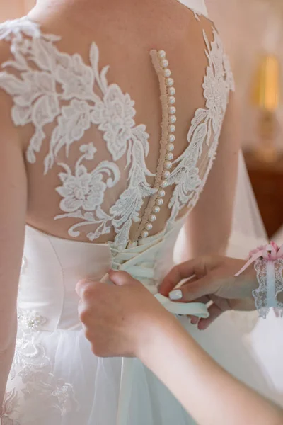 Noiva colocar um vestido de noiva no quarto — Fotografia de Stock