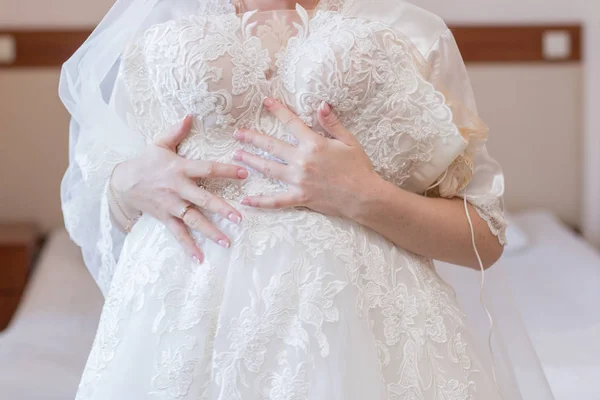 Mariée en robe de chambre et robe de mariée dans les mains — Photo