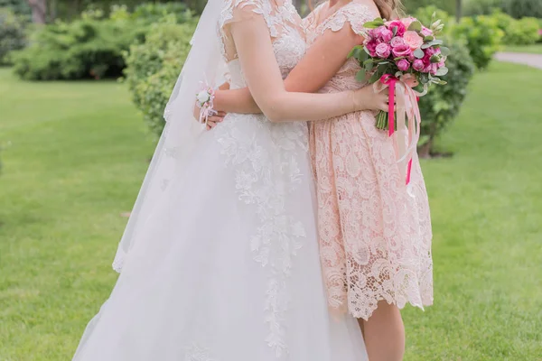 Mariée avec demoiselle d'honneur et bouquet de mariage dans le parc — Photo