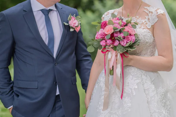 Sposa e sposo e bouquet da sposa nel parco — Foto Stock