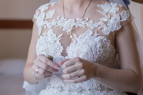 Noiva colocar um vestido de noiva no quarto — Fotografia de Stock