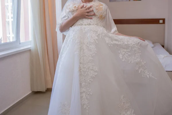 Bride in dressing gown and wedding dress in hands — Stock Photo, Image