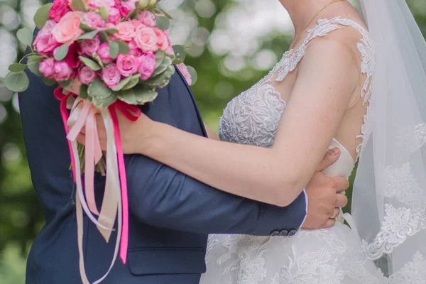Невеста и жених и свадебный букет в парке — стоковое фото