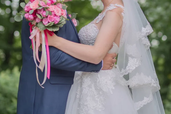 Sposa e sposo e bouquet da sposa nel parco — Foto Stock