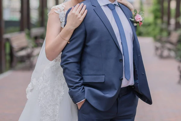 Braut umarmt den Bräutigam von hinten im Park — Stockfoto