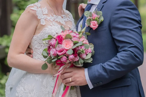 Sposa e sposo e bouquet da sposa nel parco — Foto Stock