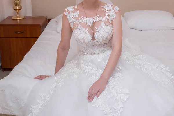 Die Braut im Brautkleid sitzt im Zimmer auf dem Bett — Stockfoto