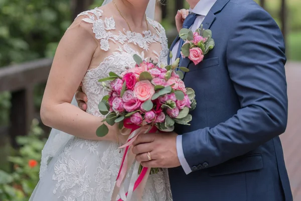 Nevěsta a ženich a svatební kytice v parku — Stock fotografie