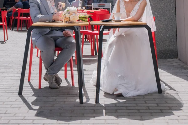 Braut und Bräutigam sitzen an einem Tisch in einem Café und trinken Kaffee — Stockfoto