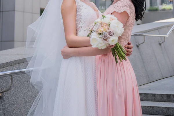 新娘与伴娘在粉红色的礼服拥抱 — 图库照片