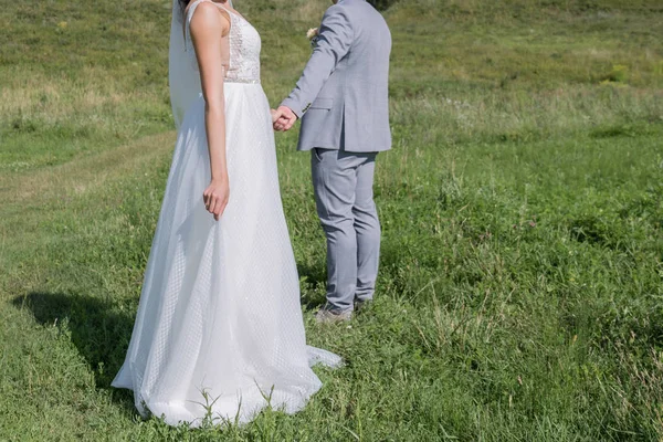 Sposa e sposo in un campo verde — Foto Stock