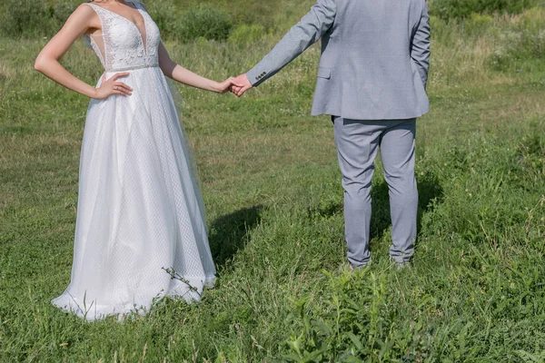 Bruid en bruidegom in een groen veld — Stockfoto