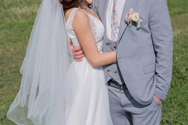 Bride and groom in a green field — Stock Photo, Image