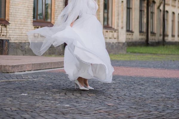 Nevěsta se závojem a svatební šaty na náměstí — Stock fotografie