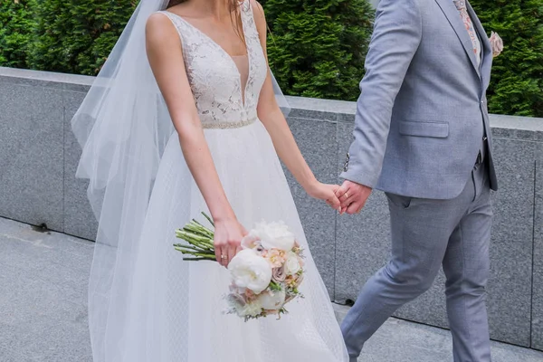Bruden och brudgummen står tillsammans nära kontors byggnaden. — Stockfoto