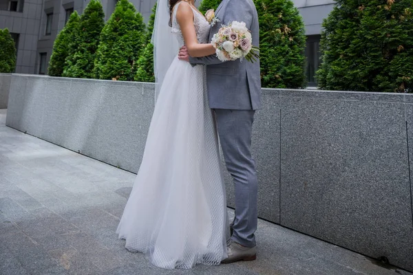 A noiva e o noivo estão juntos perto do prédio de escritórios. . — Fotografia de Stock