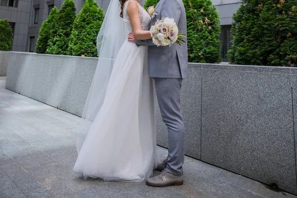 Gelin ve damat ofis binasının yakınında bir arada duruyor.